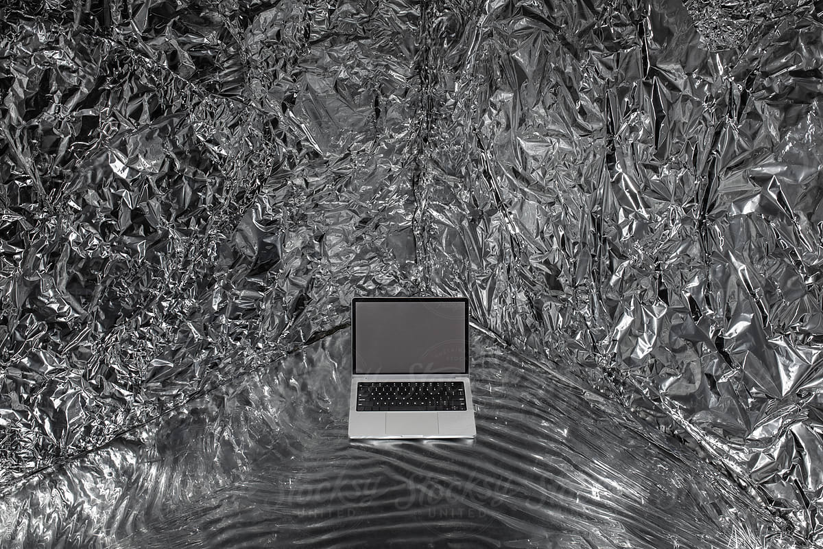 a mockup with a laptop in a space made of crumpled metallized material