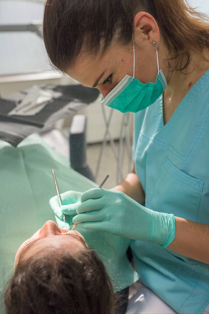 Female dentist doing oral examination to patient