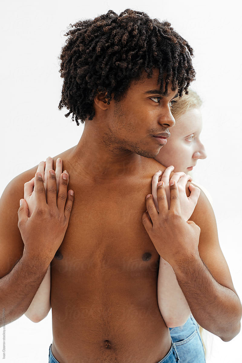 multiracial couple hugging and looking away