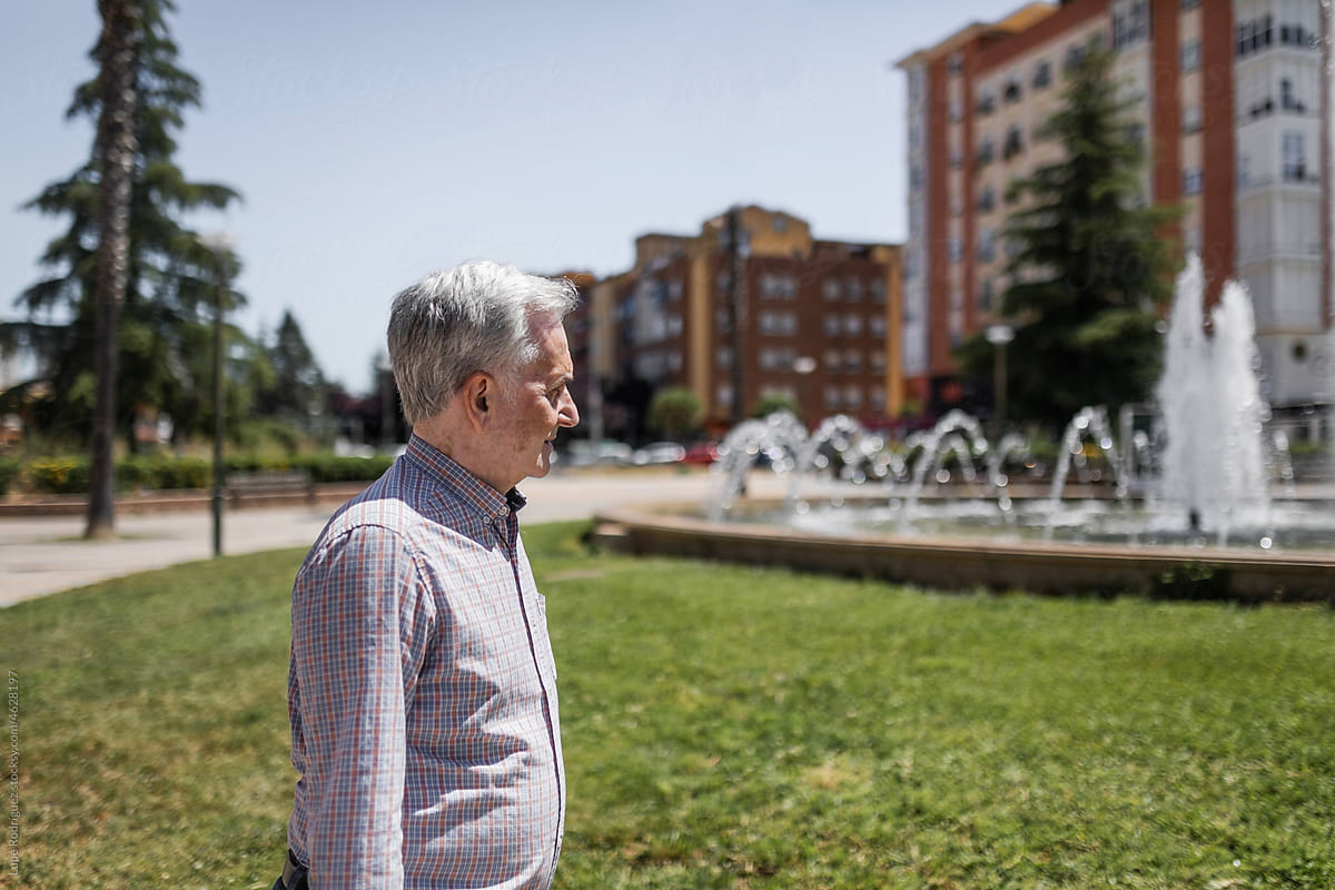 elderly man walking in a city park
