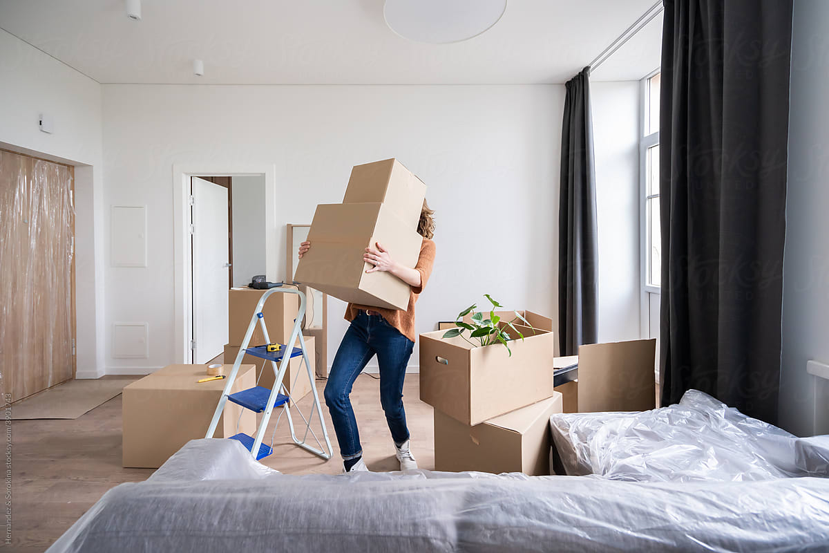 Woman Holding Heavy Boxes Indoors