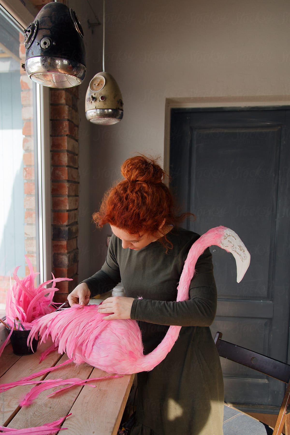 Woman making flamingo figurine in the shop