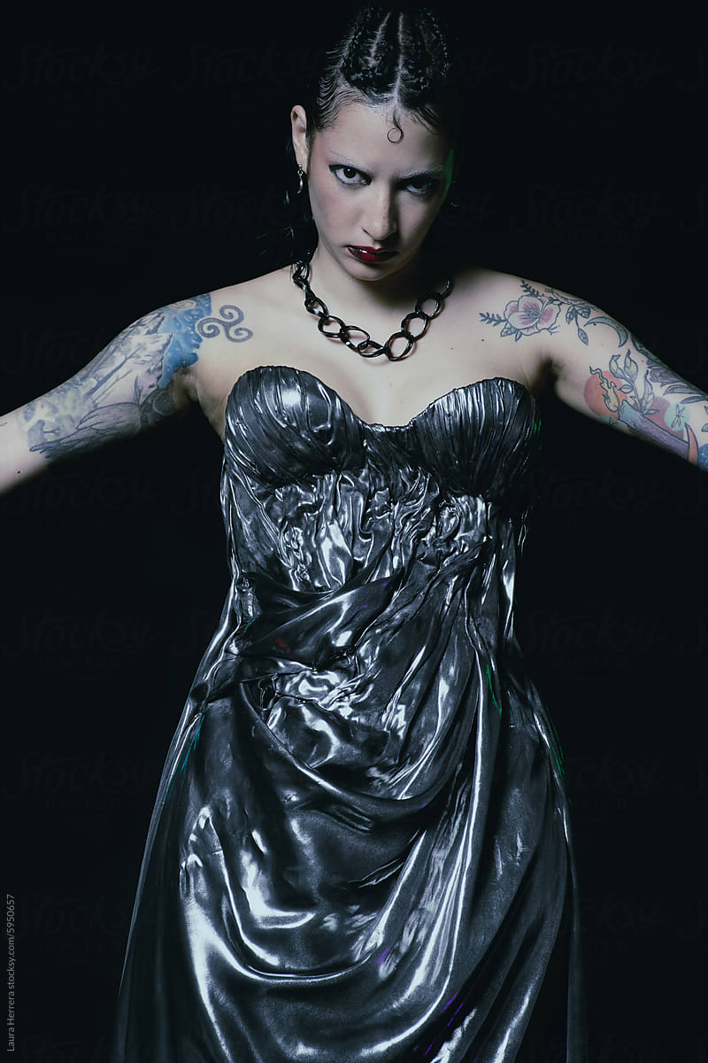 Editorial portrait of a woman with a drapped metalic silver dress