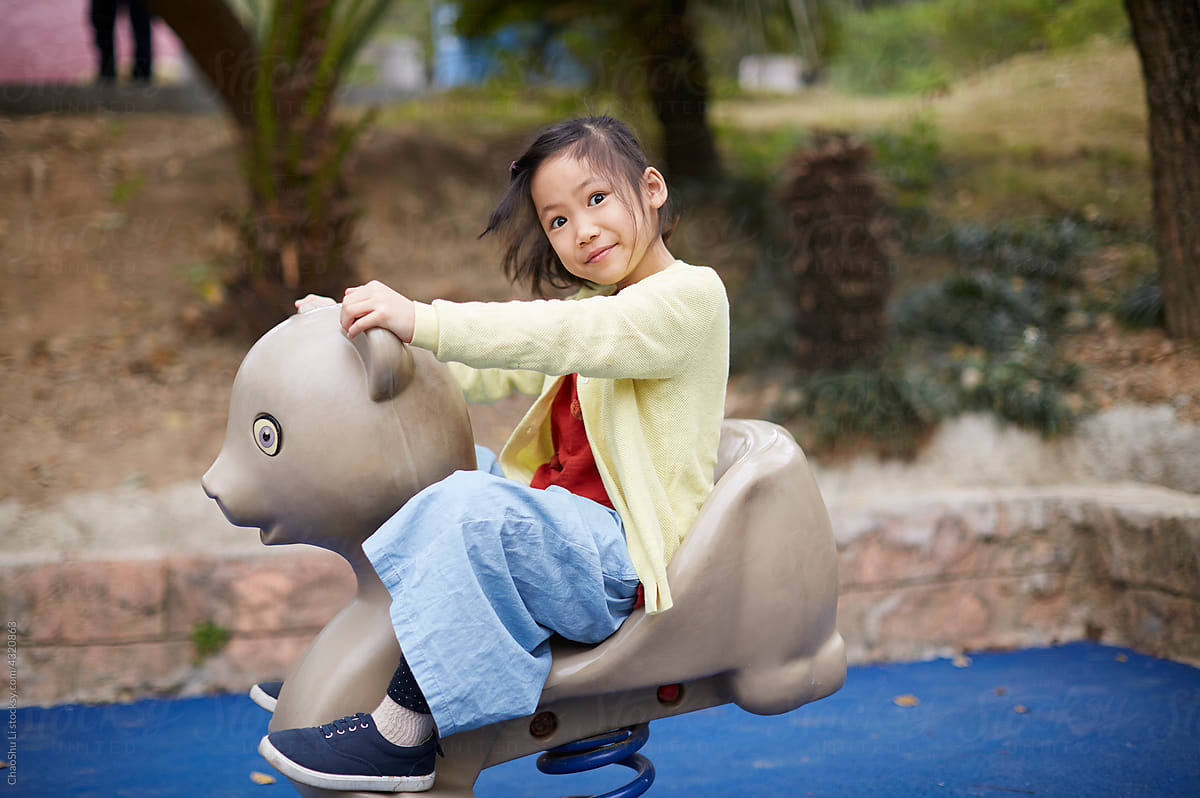 Asian girl, happy to play with animal spring chair