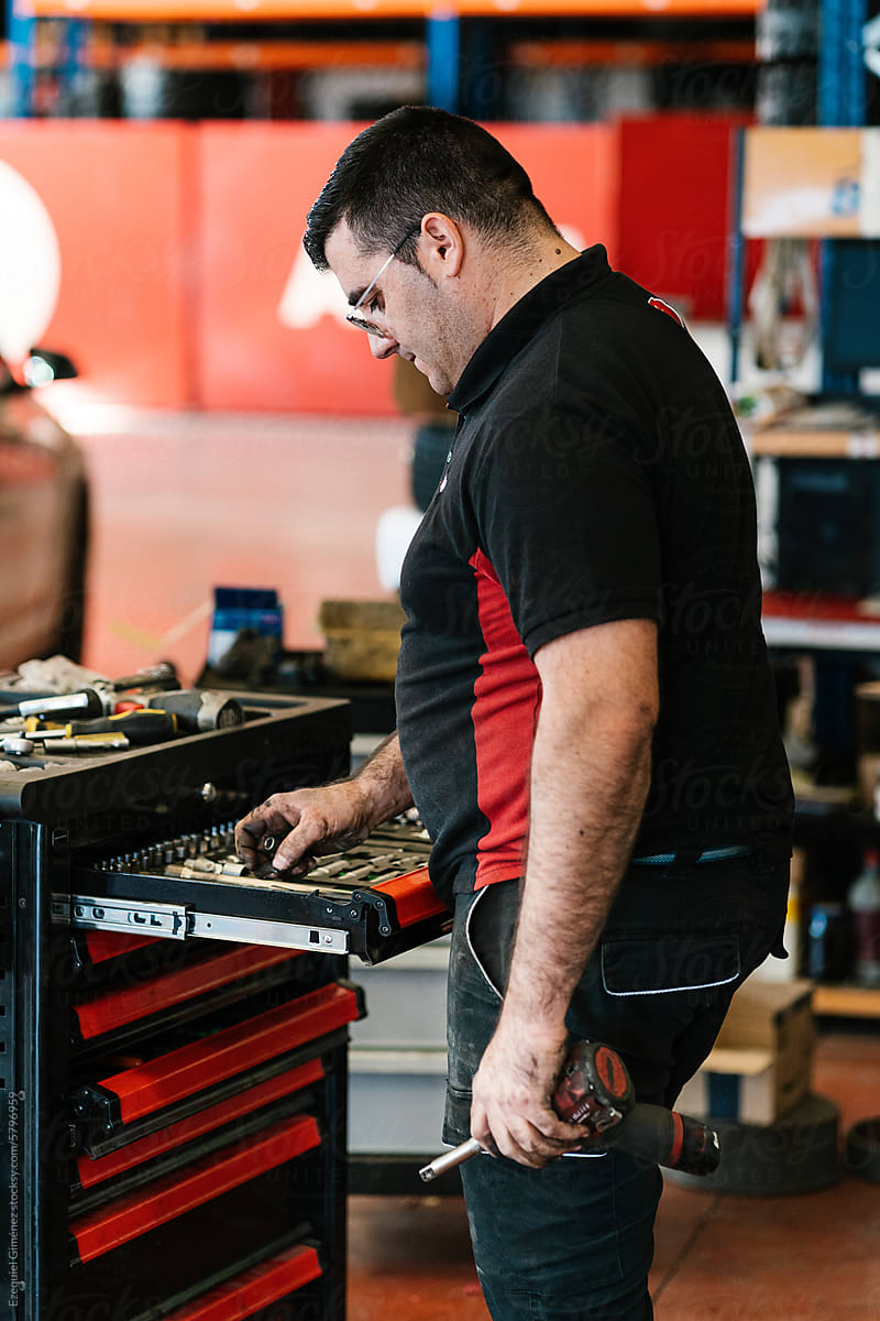 Male mechanic taking instruments from tool chest