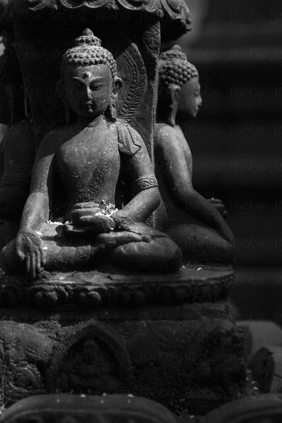 Black and white shot of close up of statue of buddha.