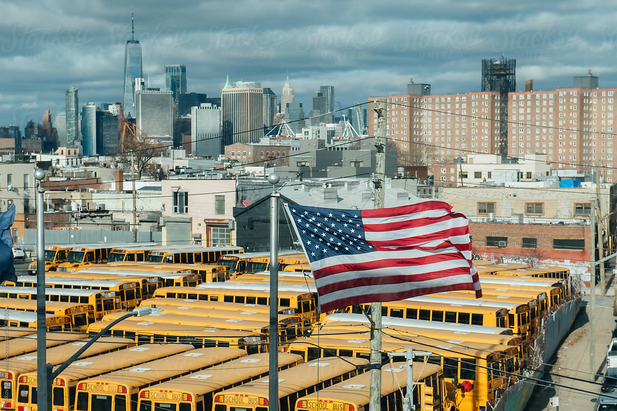 NYC cityscape - school buses and American flag
