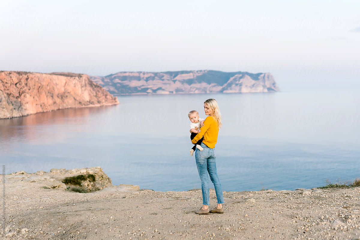 Woman with baby admiring mountain lake