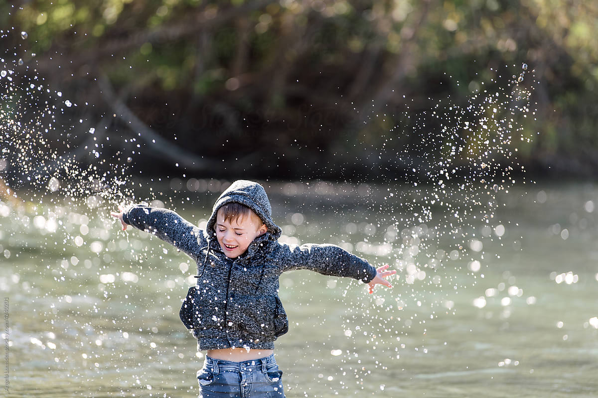 Child playing with water by a river