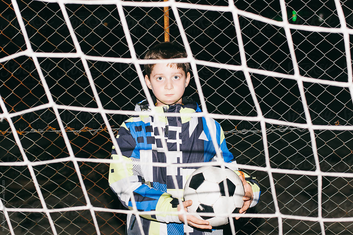 A kid holding a football ball