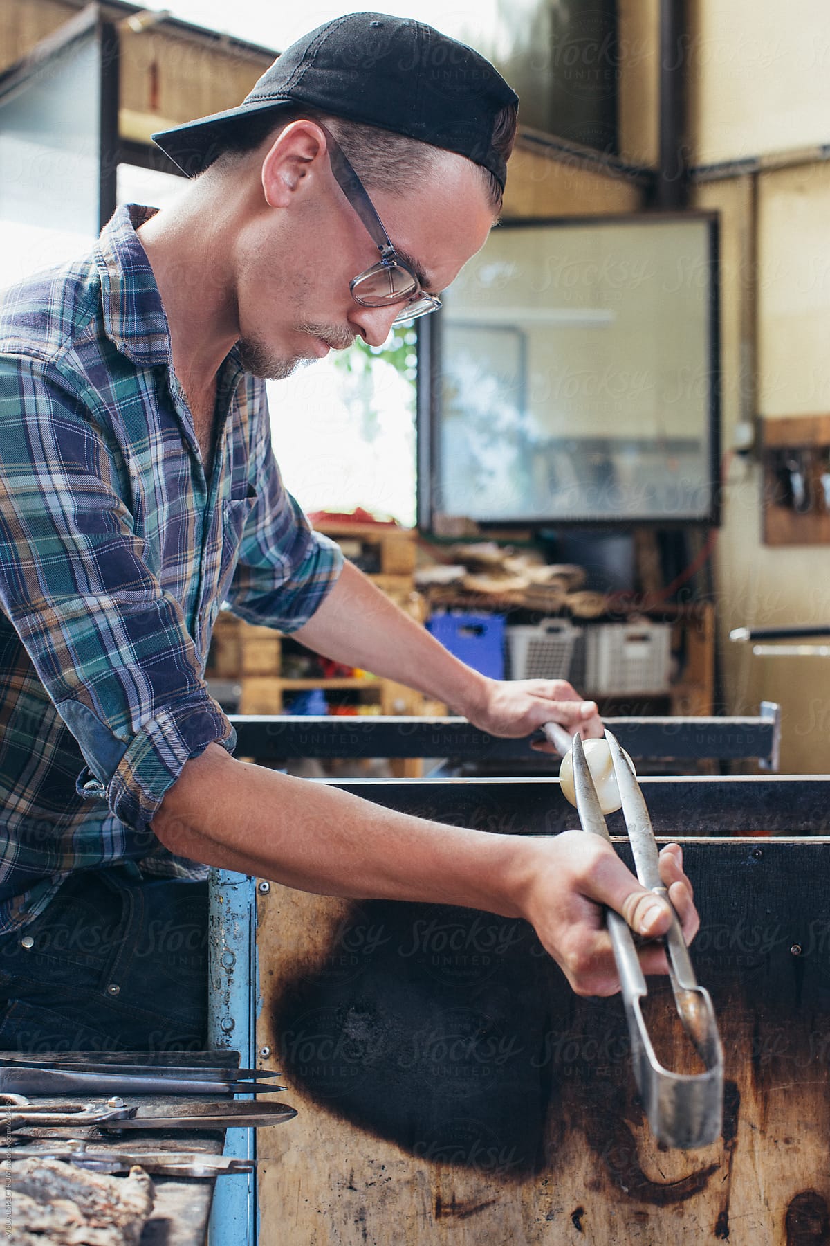 Artisan Glass Workshop - Male Hipster Artist Shaping Hot Glass With Pliers
