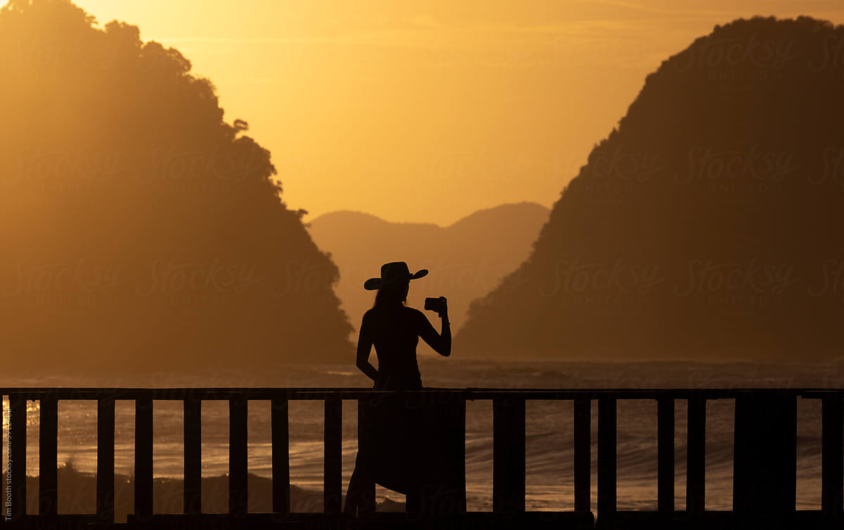 Woman taking picture of sunset