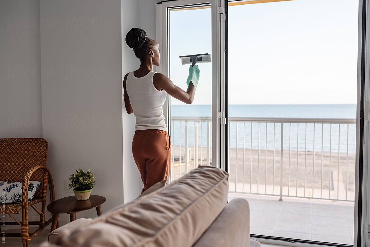 Black woman washing balcony door