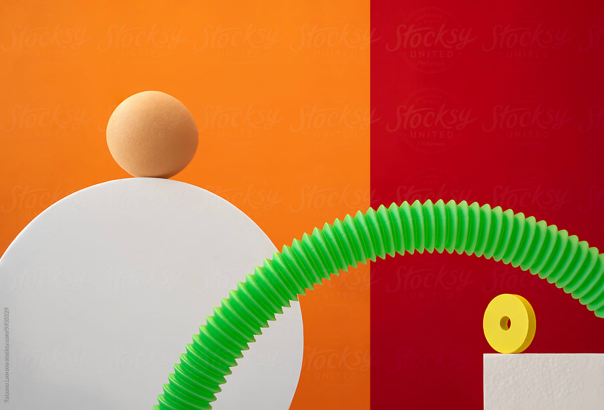 Abstract composition of spheres, cubes, corrugation on orange backdrop
