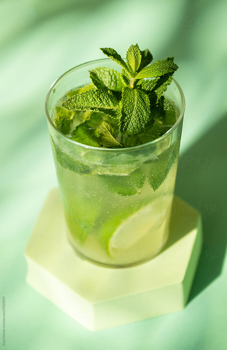 Classic rum mojito cocktail against green background