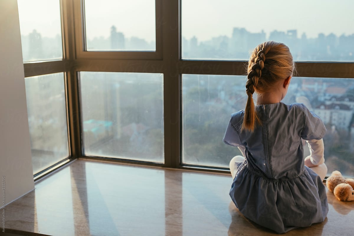 Young Girl on Windowsill with City View