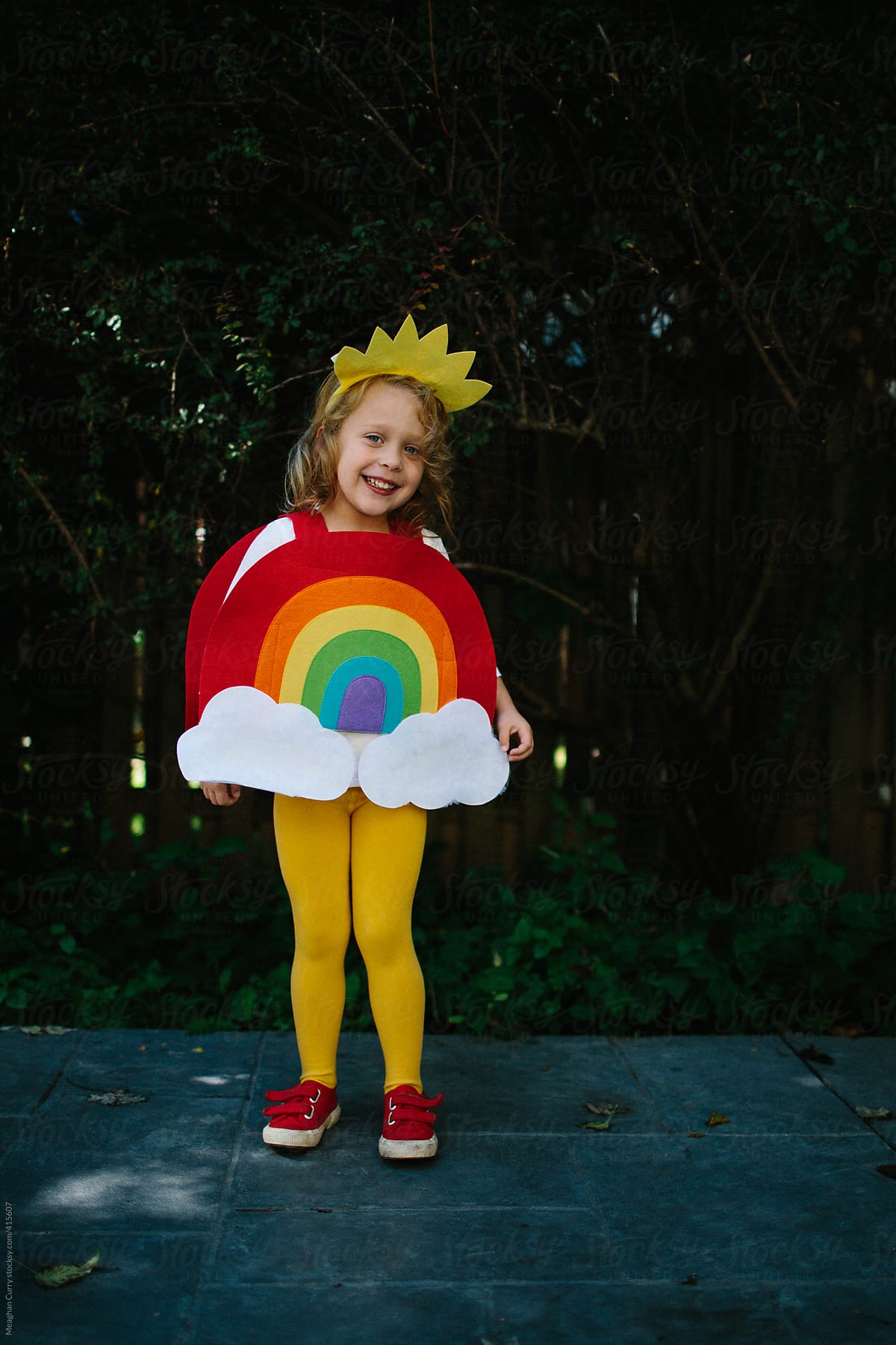 little girl dressed up in a rainbow halloween costume