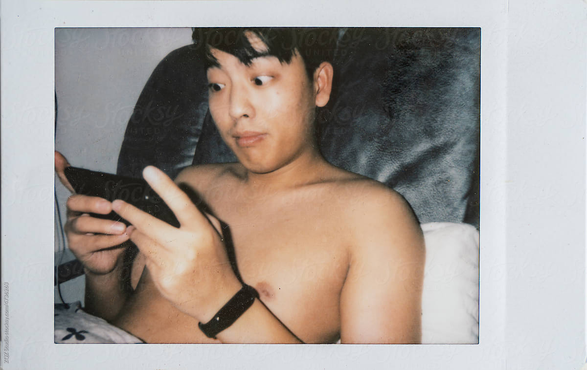 Polaroid photo of young man using cell phone by ZQZ Studio for Stocksy United