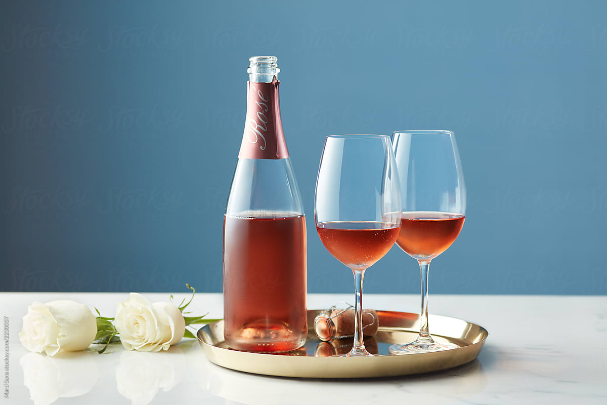 Rose sparkling wine with glasses on tray.