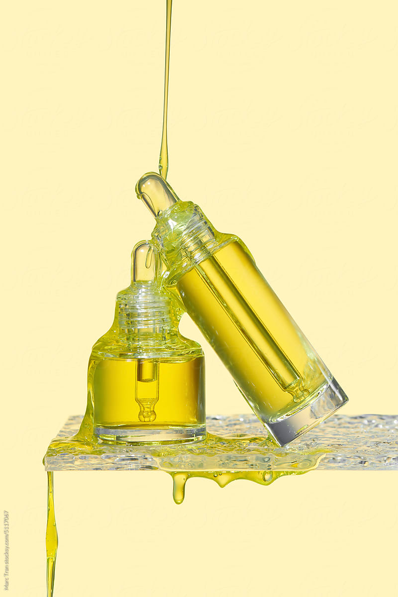Two cosmetic bottles with oil splash.