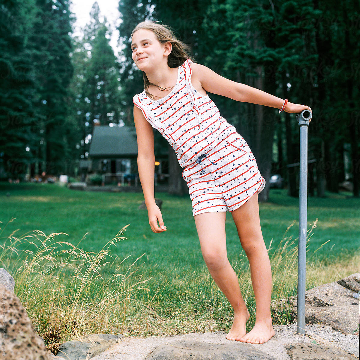 Ten Year Old Girl In Stars And Stripes Romper At A Cabin On A