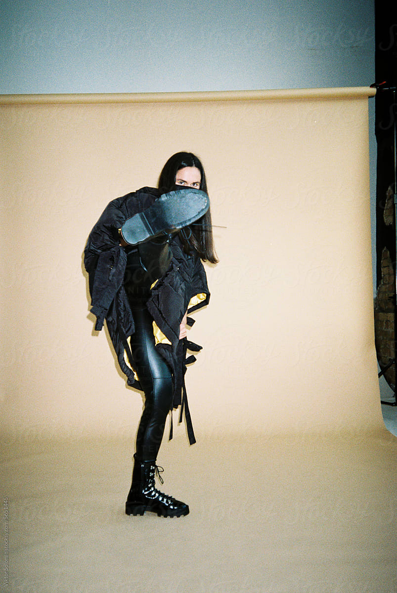 Fashion woman in protective mask demonstrating leg high kick