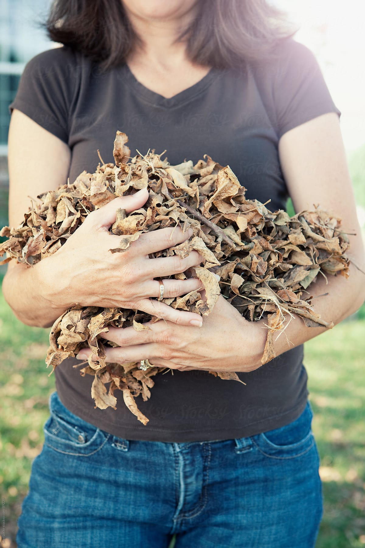 Autumn: Woman Holding Pile of Leaves