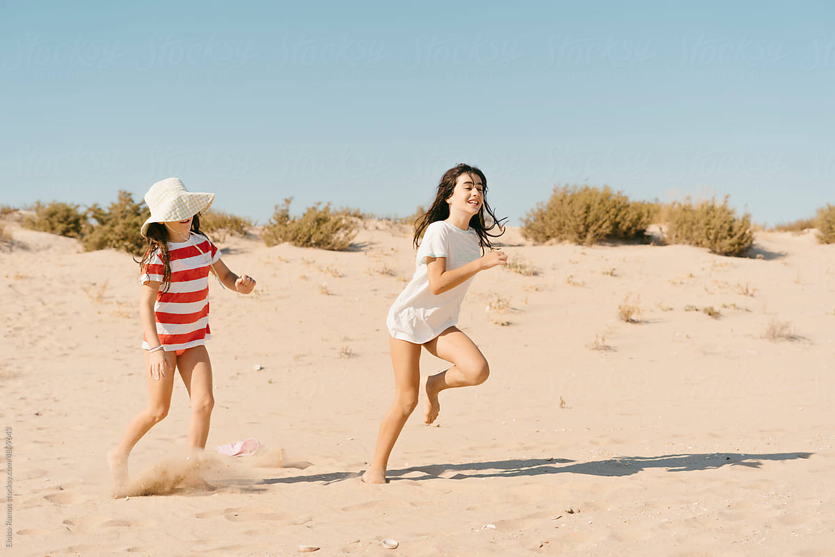 Little girls running through the sand
