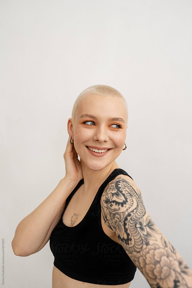 Cheerful informal young woman with short hair and tattoo