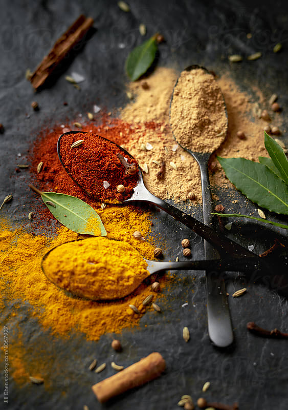 Colourful spice powder seasonings on dark background