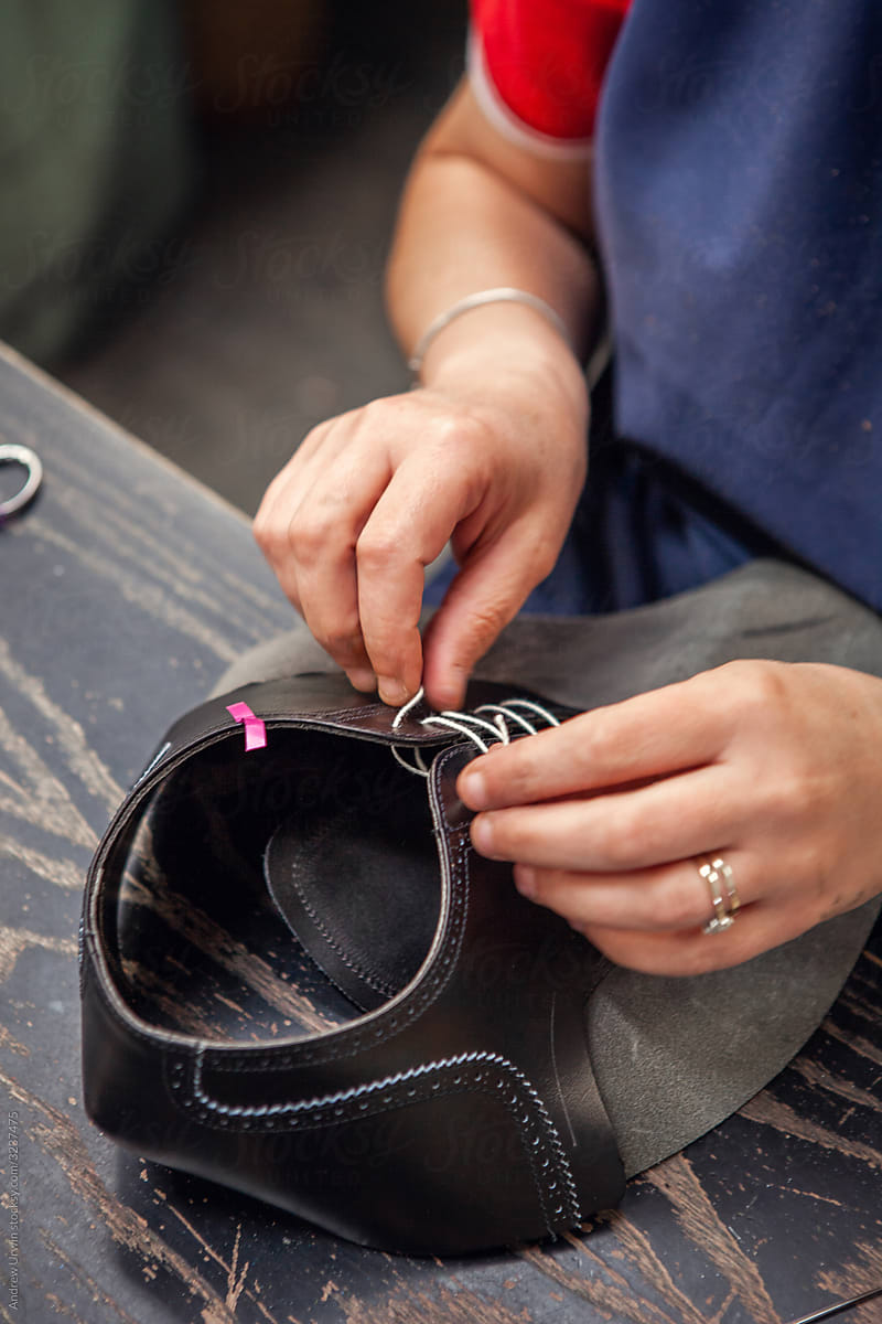 A worker sewing shoes together