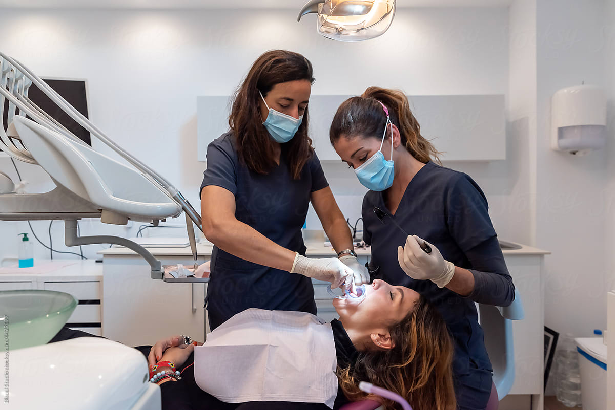 Female dentists treating patient with cheek retractor