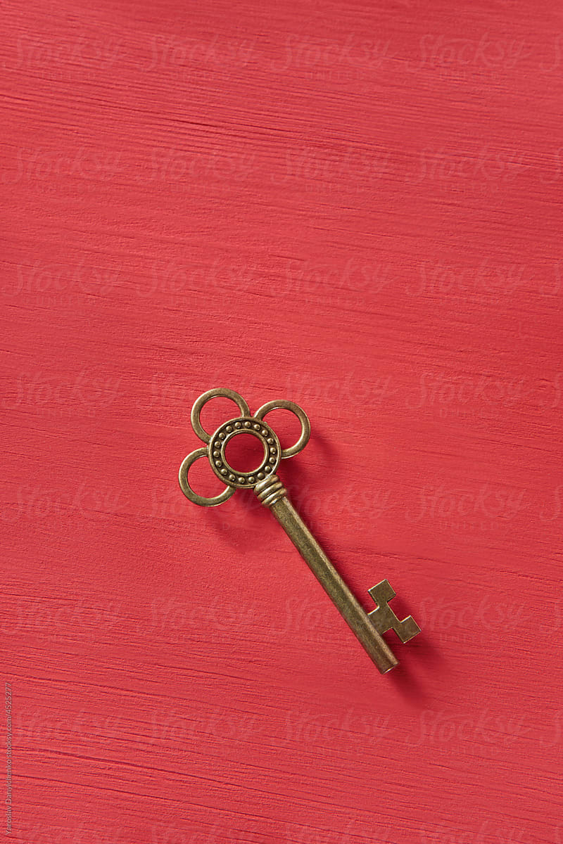 Vintage golden key lying on red background