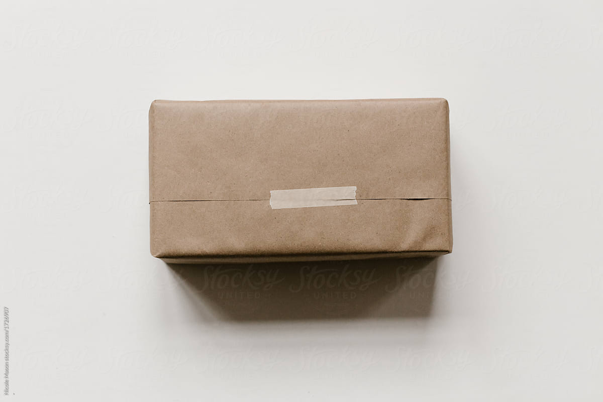 gift wrapped in brown kraft paper on white background