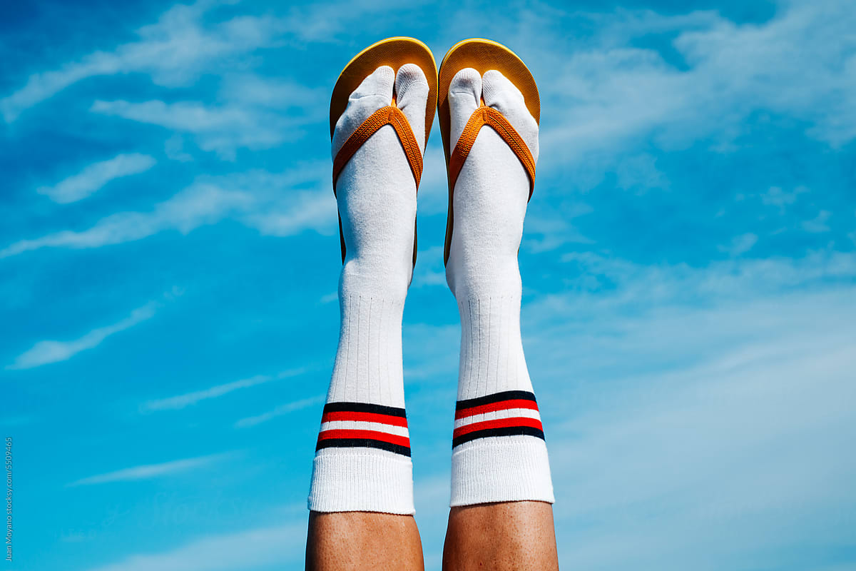 wearing socks and flip-flops upside-down against the sky