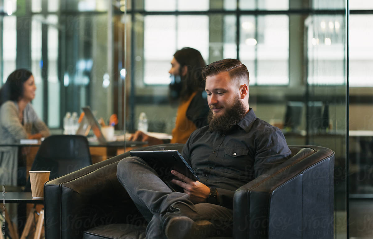 Office: Man In Lounge Area Using Digital Tablet