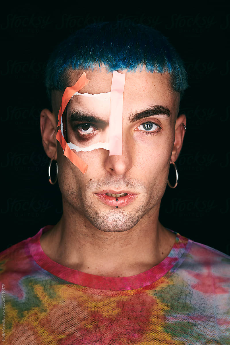 Confident man with blue hair and printed photo cutout eye lookin