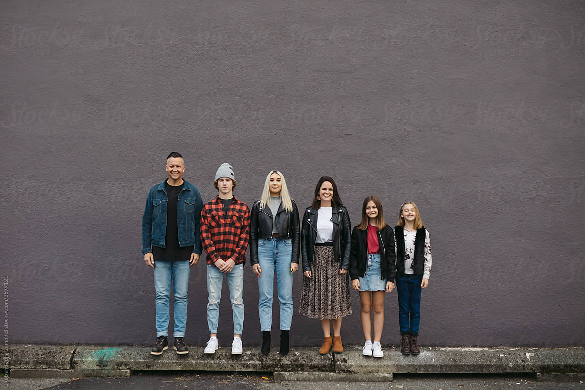 Family lined up against wall in order of tallest to shortest.