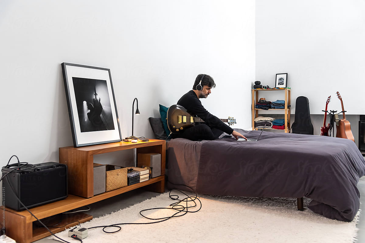 Guitarist with laptop having music practice at home