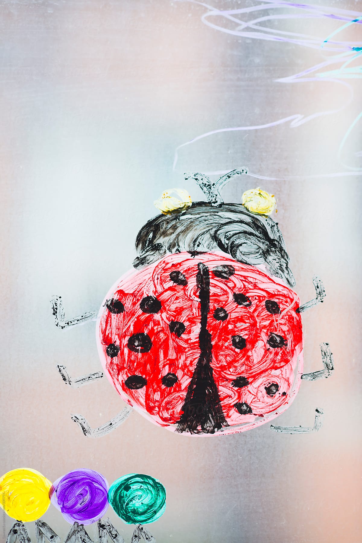 Colorful ladybug drawing on glass of window
