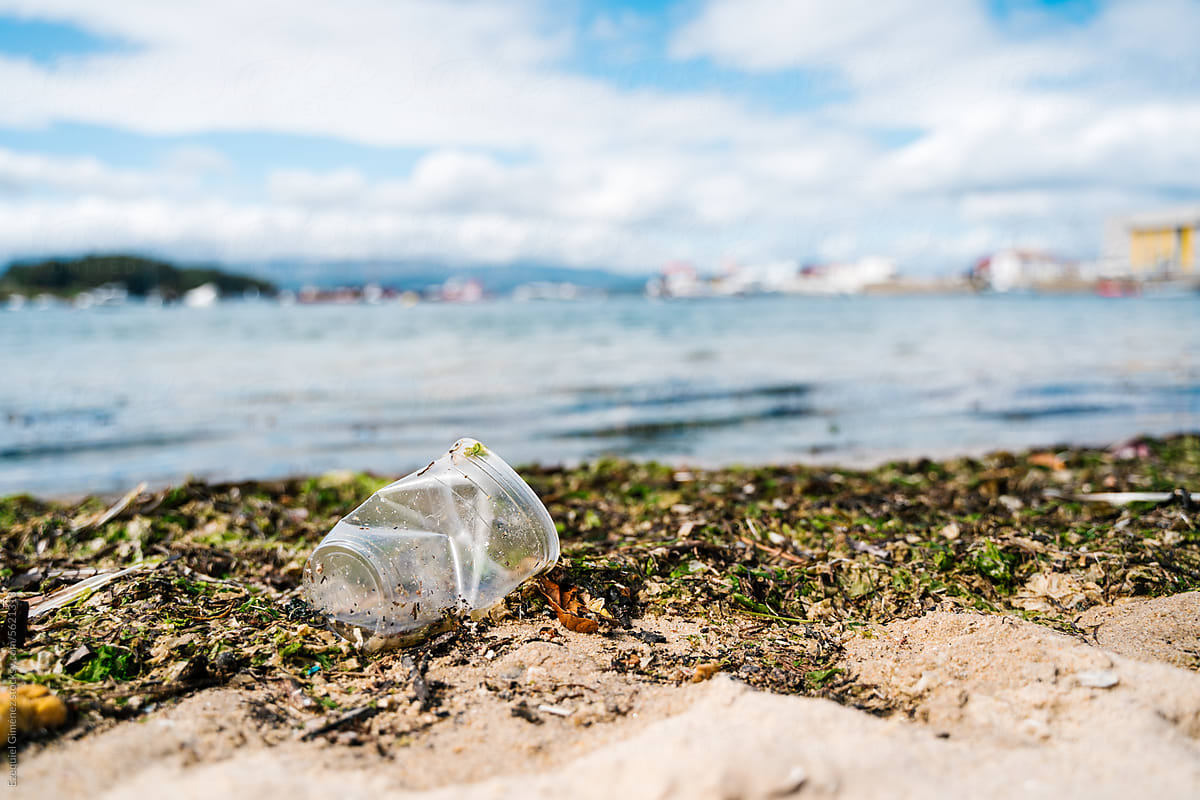 Plastic glass litter on sandy beach