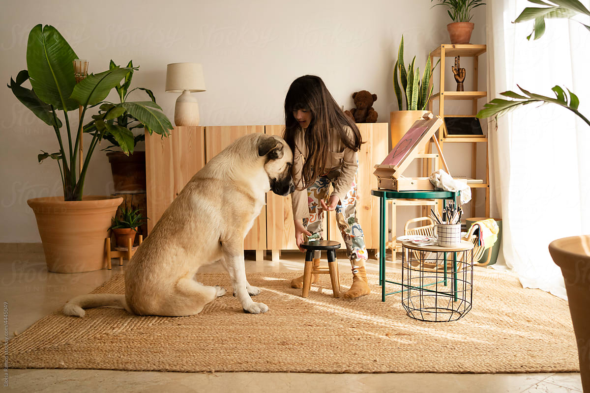 Girl playing with her dog at home