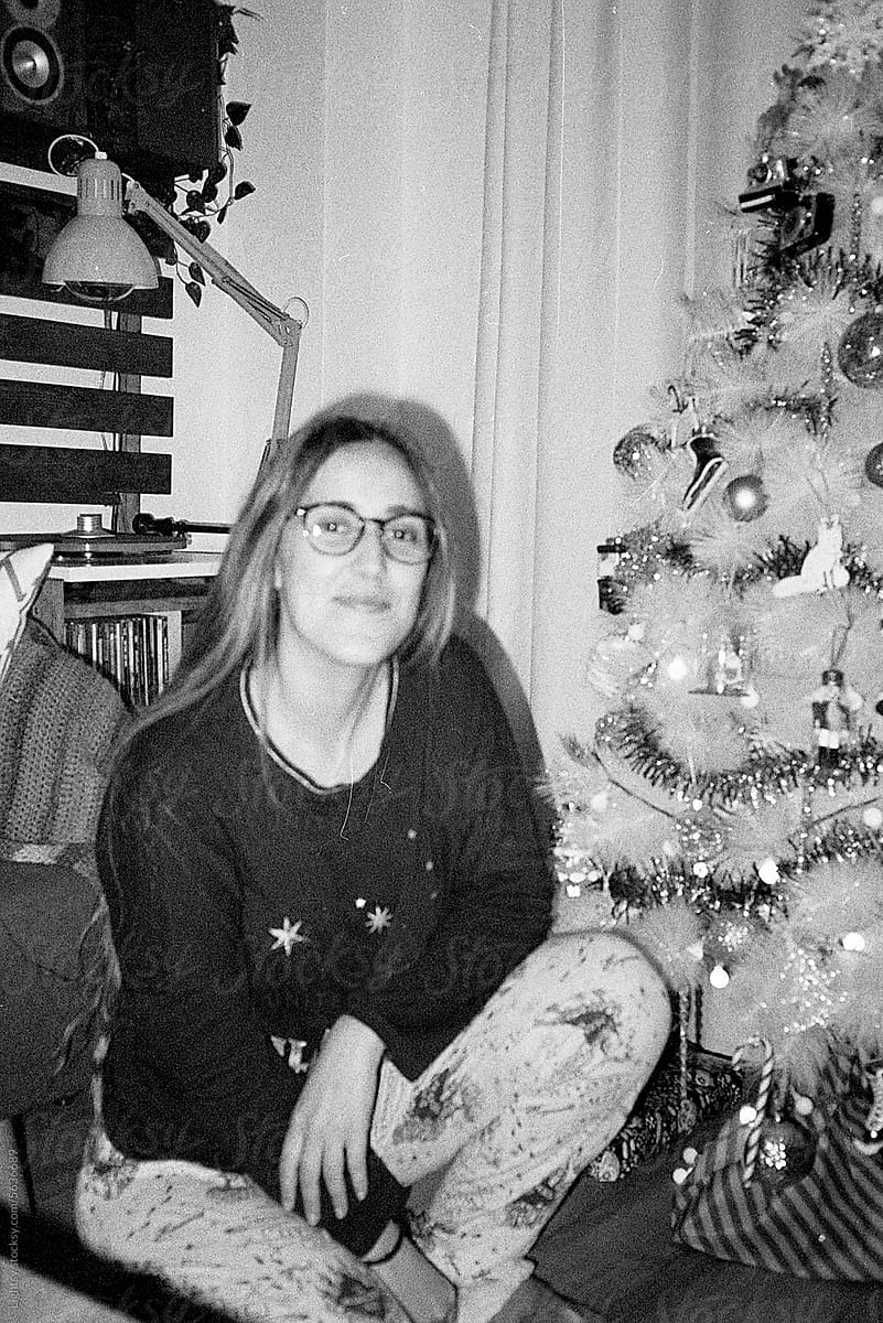 Woman in pajamas next to a Christmas tree