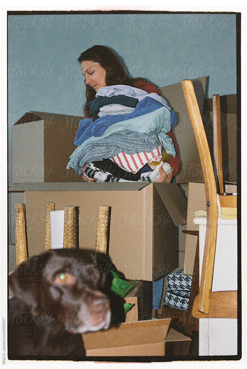 A woman and her dog amongst the things to move.