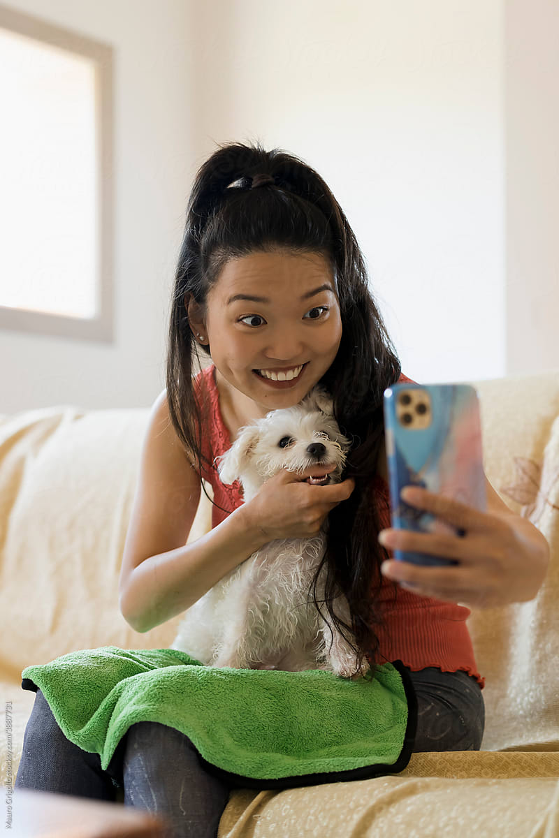 Asian woman taking a selfie with her beautiful dog