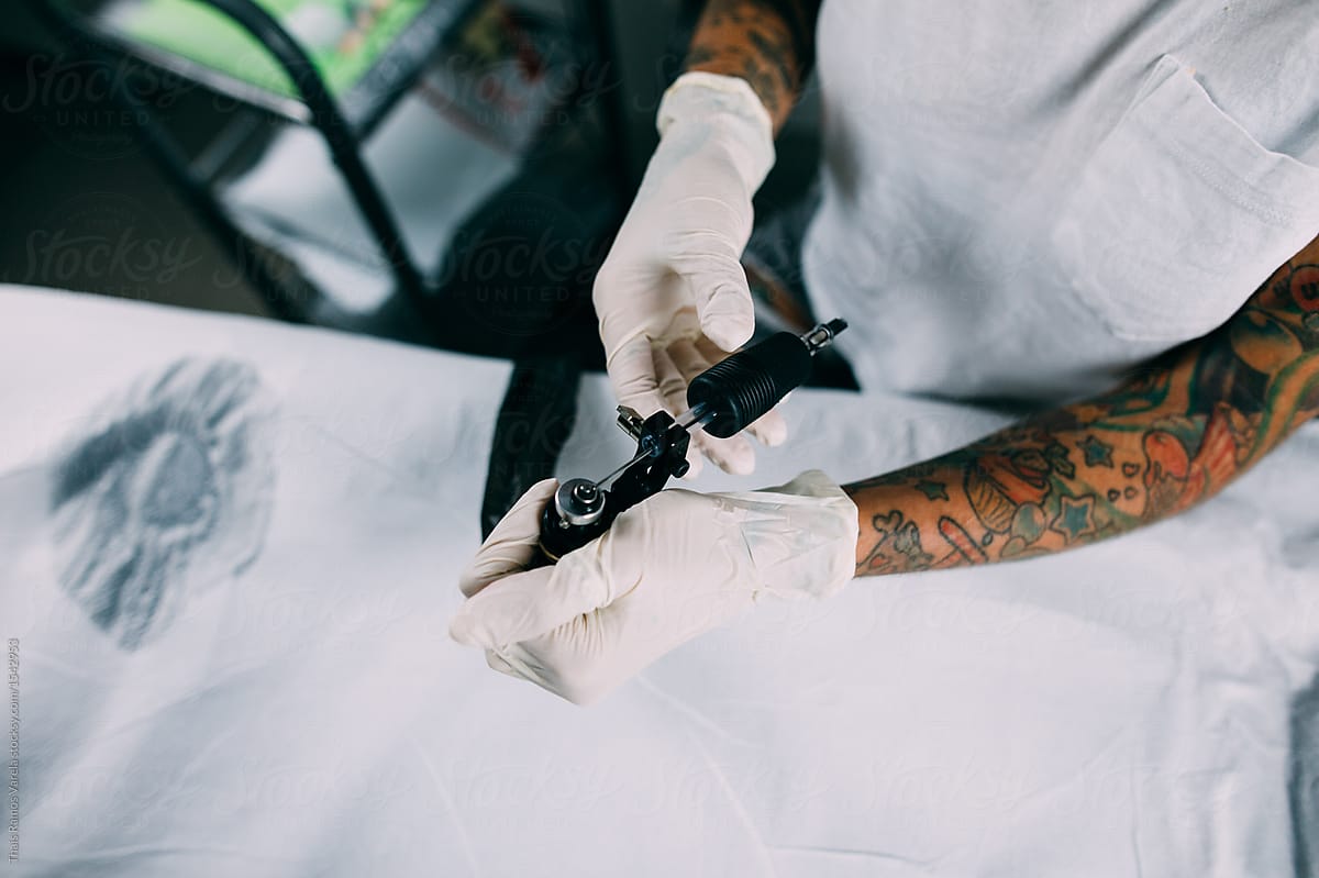 beautiful tattoo artist preparing the tattoo machine