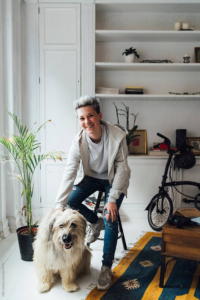 Happy Hipster Woman Playing With Dog At Home