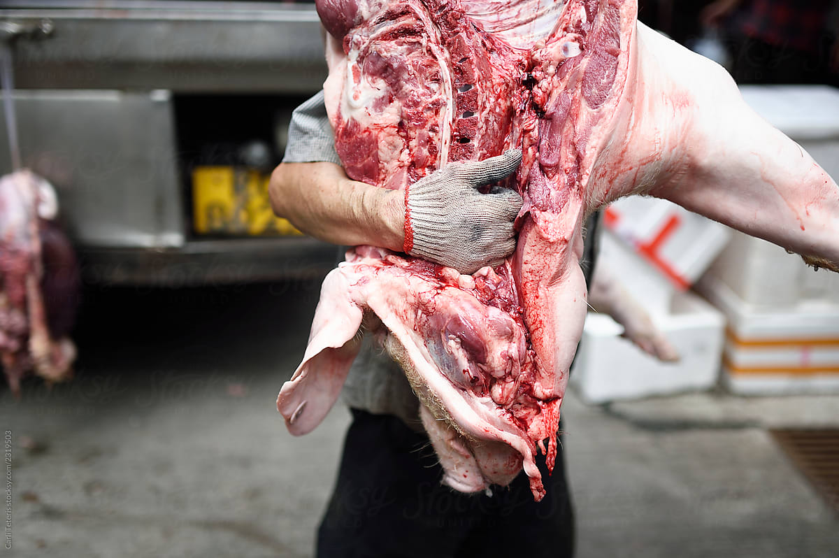Man carrying half a pig carcass
