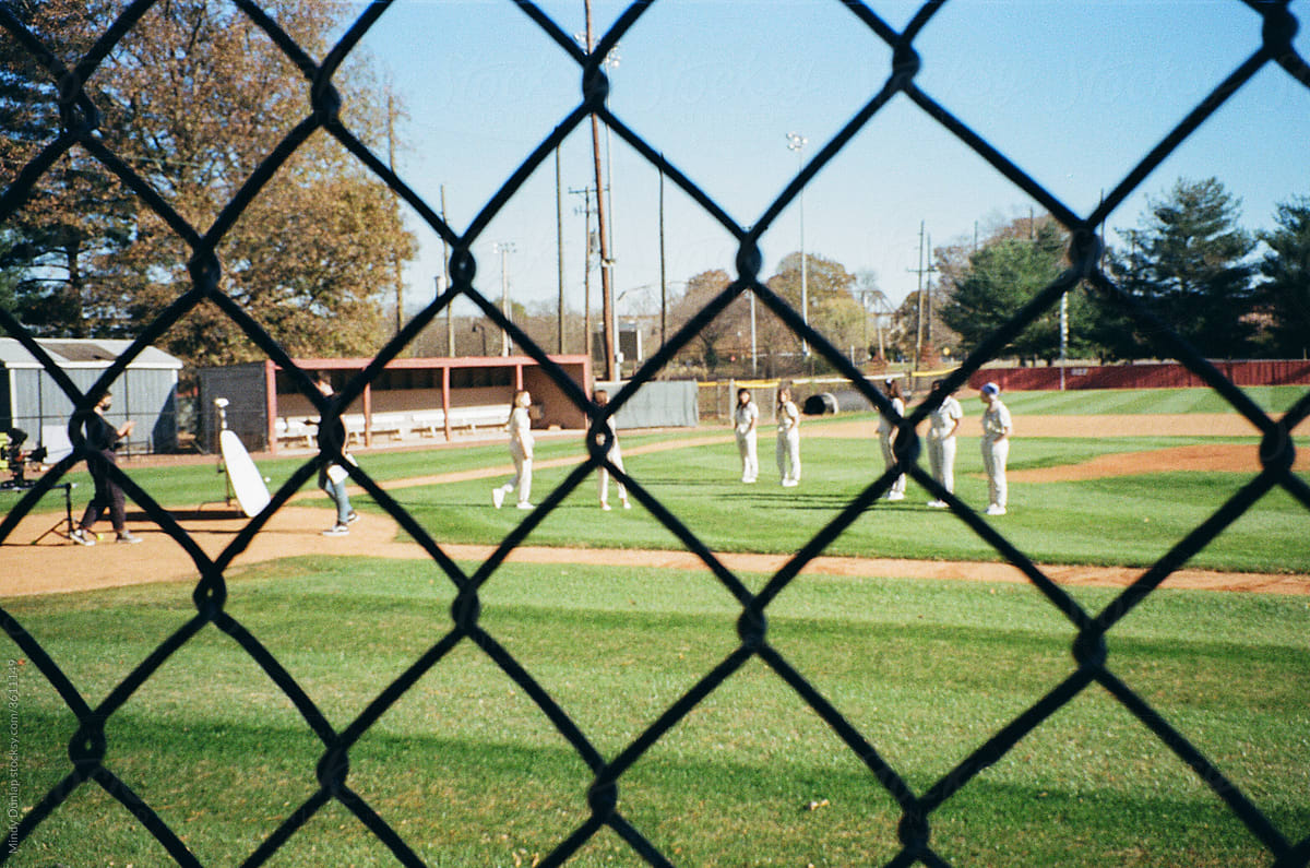 Film crew and actors on a baseball field