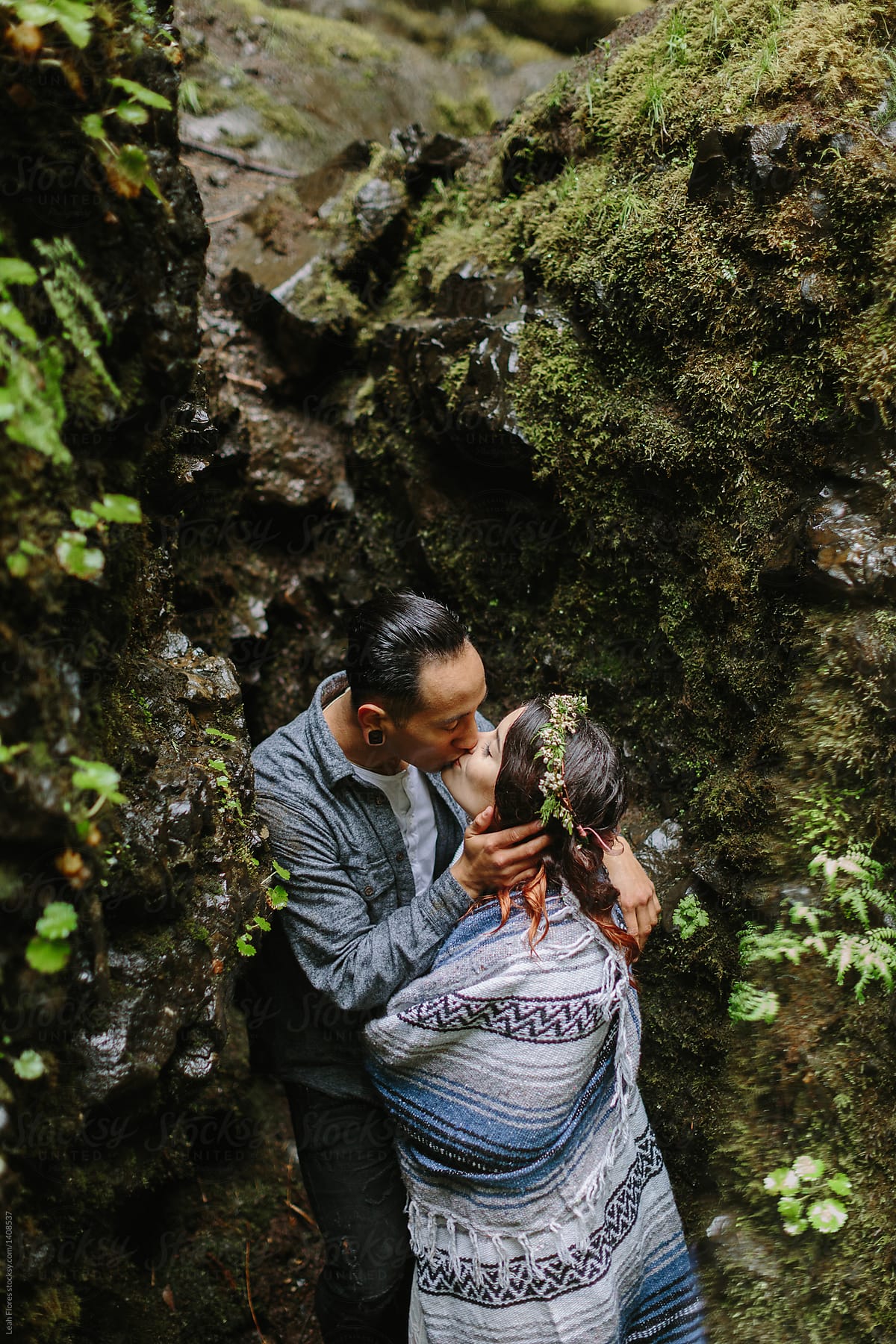 Couple Kissing between Mossy Rocks